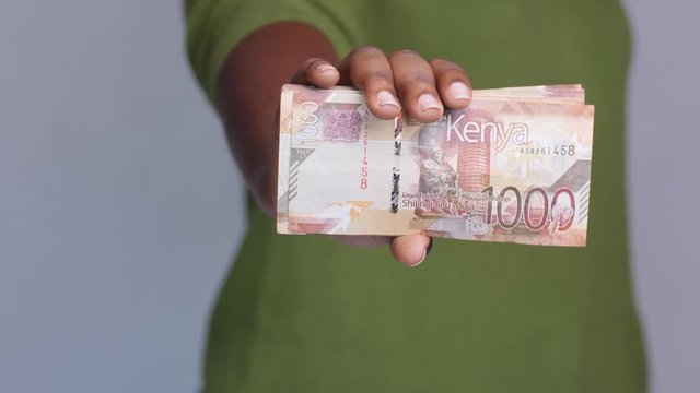 Close up shot of female hand revealing  Kenyan shillings money cash.