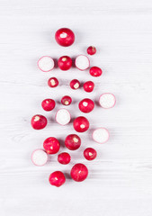 Naklejka na ściany i meble Flat lay isolated fresh red radishes on white board or table background. horizontal