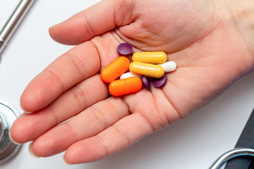 colorful medical pills, tablets in hand. Drug protection, treatment of viruses, antiviral, diseases concept.