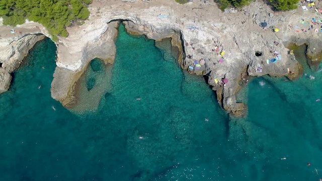 Grotto of Pula town, clean blue water of Adriatic sea with rocky beach, Istria region