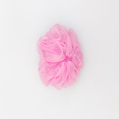 top view of pink cleaning bath puff ball sponge for body skincare shower scrubbing on white background