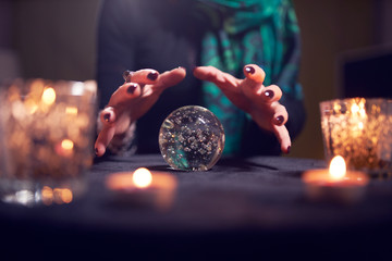Close-up of fortune-teller's hands with ball of predictions