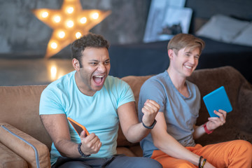 Two friends watching tv program and feeling excited