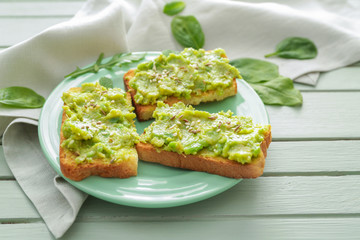 Plate with tasty avocado sandwiches on table