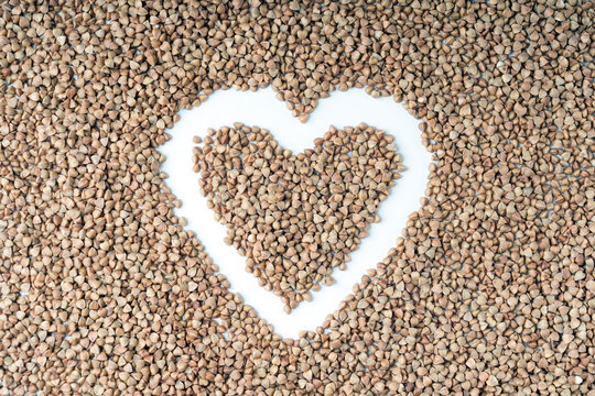 buckwheat heart shape close-up on a white background, selective focus, tinted image