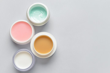 Jars of cream on light background