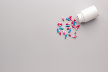 Bottle with contraceptive pills on grey background
