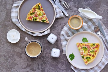 Open savory shortcrust pastry pie with ham, broccoli and egg filling on a gray concrete background. Breakfast for two on Valentine's Day. Savory pies. Top view.