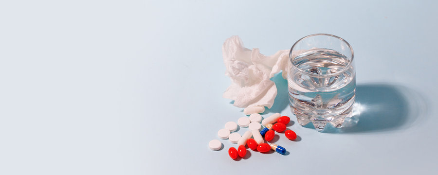 Vaccines Covid-19 Antivirus Corona virus. Glass of water and set of piil on blue background, minimal concept of antivirus pharmacy, Prevention of the spread of virus and pandemic
