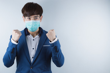 Fototapeta na wymiar The business man wearing mask for protecting coronavirus and pm 2.5 and show his hand to fight them. Coronavirus and Air pollution pm 2.5 concept.
