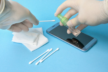 smartphone sanitizer disinfection. virus protection. blue background.