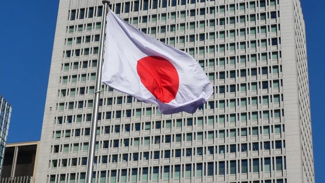 Japan flag with background of modern high-rise building in Tokyo,Japan