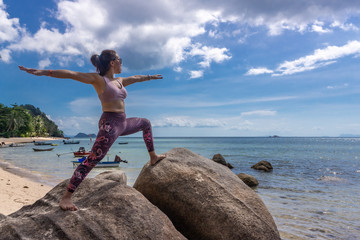 Asian Thai woman practicing yoga in Haad Chao Phao beach, Koh Phangan island