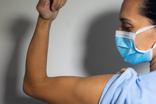 Empowered Nurse. The Nurse Shows Her Biceps As A Gesture Of Strength. The Importance Of Women In Our World.