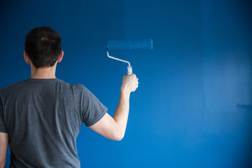 Phantom blue color on wall. Painting interior wall with paint roller in new house.