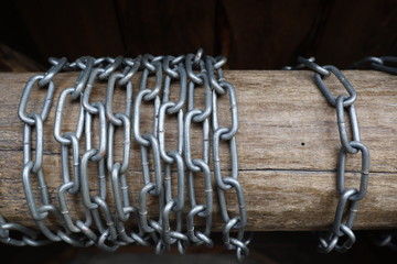 Fototapeta na wymiar iron chain rings are wrapped around a wooden log