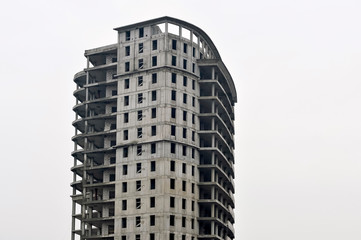 Fototapeta premium Concrete gray high-rise building partially without external walls. Background