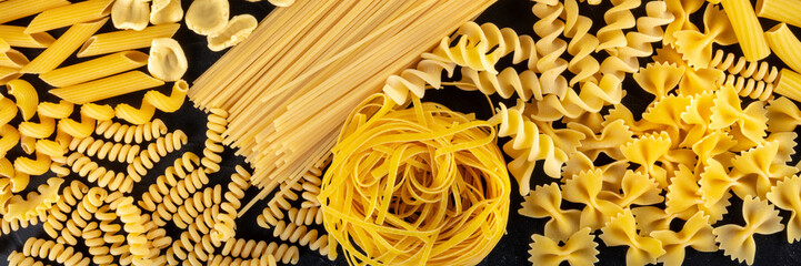 Italian pasta panoramic banner, a flat lay of many different pasta types, shot from the top on a...
