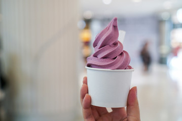 Purple Sweet Potato ice cream soft serve. Woman holding a cup of soft serve ice cream with yogurt sweet potato flavour. (isolated)