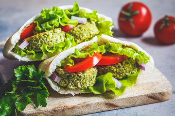 Falafel with fresh vegetables in pita bread on the board. Healthy vegan food concept.