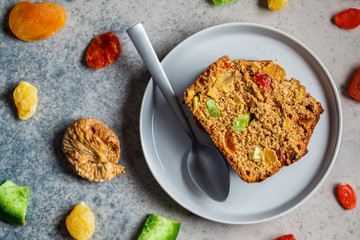 Piece of dried fruit bread on a gray plate, top view.