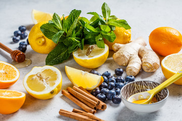 Healthy ingredients for immunity and anti-flu. Citrus fruits, ginger, honey, blueberries and mint on a white background, health concept.