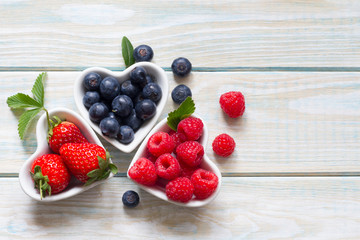Raspberries  blueberries and strawberry in the heart still life