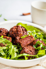 Beetroot Falafel with arugula leaves in a white bowl. Healthy vegan food concept.