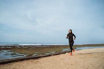 woman with head scarf running. sport muslim woman run outdoor on summer