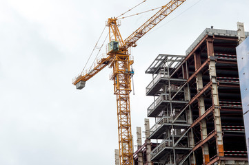 Construction of the frame of high-rise buildings against the overcast sky. Background