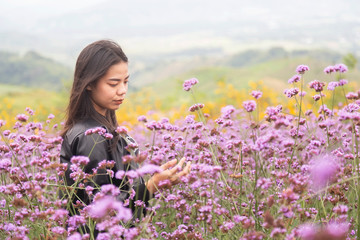  Asian women are standing to admire the beauty of flowers in the mountain gardens at Phetchabun province , Thailand. Travel with family cancept.