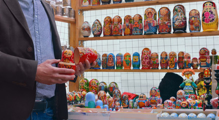 Matryoshka dolls at a souvenir stall. Man holding Russian nesting doll called Matryoshka.