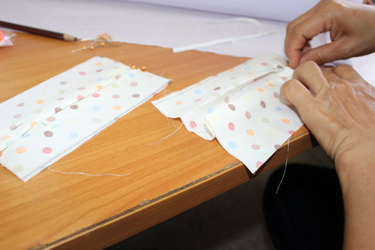 Young women helping to sew nose masks to prevent covic disease 2019