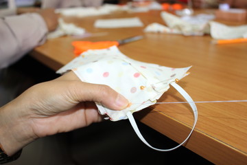 Young women helping to sew nose masks to prevent covic disease 2019