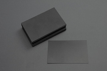 stack and single black blank textured business cards on dark paper background, us size 3.5 x 2...