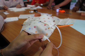 Young women helping to sew nose masks to prevent covic disease 2019
