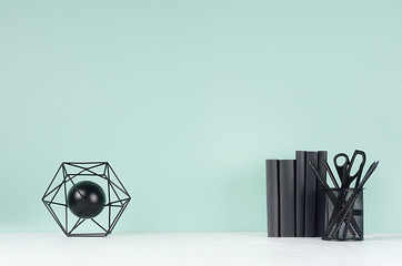 Spring soft students workplace with black stationery, books and decoration atom statuette on soft...