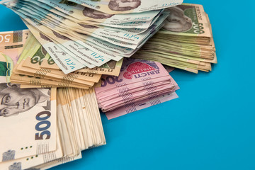 Ukrainian hryvnia money new bills 1000 and 500 isolated on blue. Stack of money.