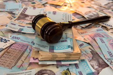 wooden hammer on ukraine money as background. 500 and 1000 new uah grivna