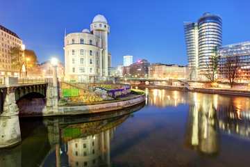 Danube Canal of Vienna, Austria. At the right the new UNIQA-Tower and opposite the historic building Urania.
