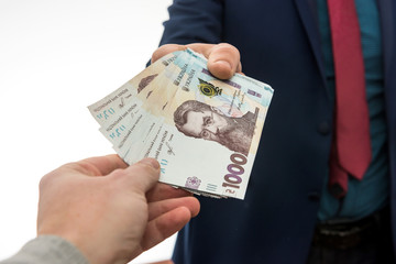 businessman gives or takes a bribe of money. Ukrainian hryvnia, new banknotes of 1000 hryvnia.