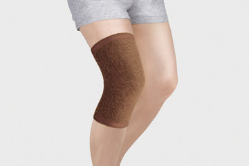 Knee Support Brace on leg isolated on white background. Orthopedic Anatomic Orthosis. Braces for knee fixation, injuries and pain. Orthotics. Foot orthosis. Knee Joint Bandage Sleeve. Elastic Sports 