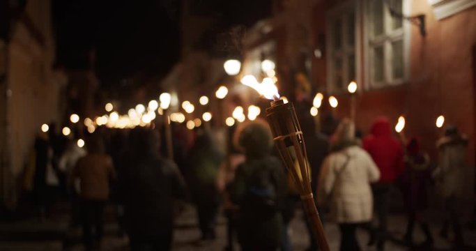 Torchlight procession protest march at night people walk with burning torches