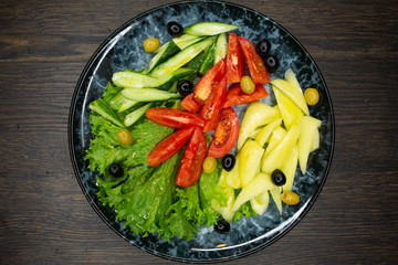  assorted fresh vegetables, tomato, cucumber, pepper, lettuce, olives