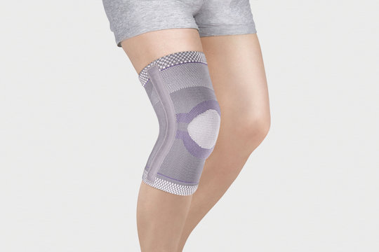 Knee Support Brace on leg isolated on white background. Orthopedic Anatomic Orthosis. Braces for knee fixation, injuries and pain. Orthotics. Foot orthosis. Knee Joint Bandage Sleeve. Elastic Sports 