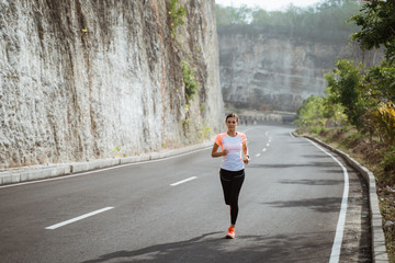 sport woman running on sideroad. fit woman jogging on empty road