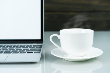 Laptop mockup and coffee cup with wood background on the work table