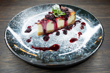 delicious creamy dessert, cheesecake with cherry jam, a leaf of mint and whipped cream