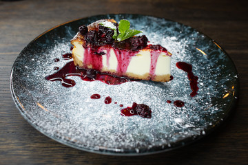 delicious creamy dessert, cheesecake with cherry jam, a leaf of mint and whipped cream
