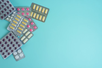coronavirus tablets top view. background image. capsules and tablets with blisters on a blue background. treatment of infection during a pandemic. health care